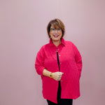 Woman wearing a pink quilted jacket against a plain background