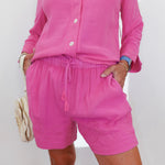 Person wearing a pink outfit with shorts and a top on a white background