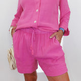 Person wearing a pink outfit with shorts and a top on a white background