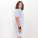 Woman wearing a light blue dress against a white background