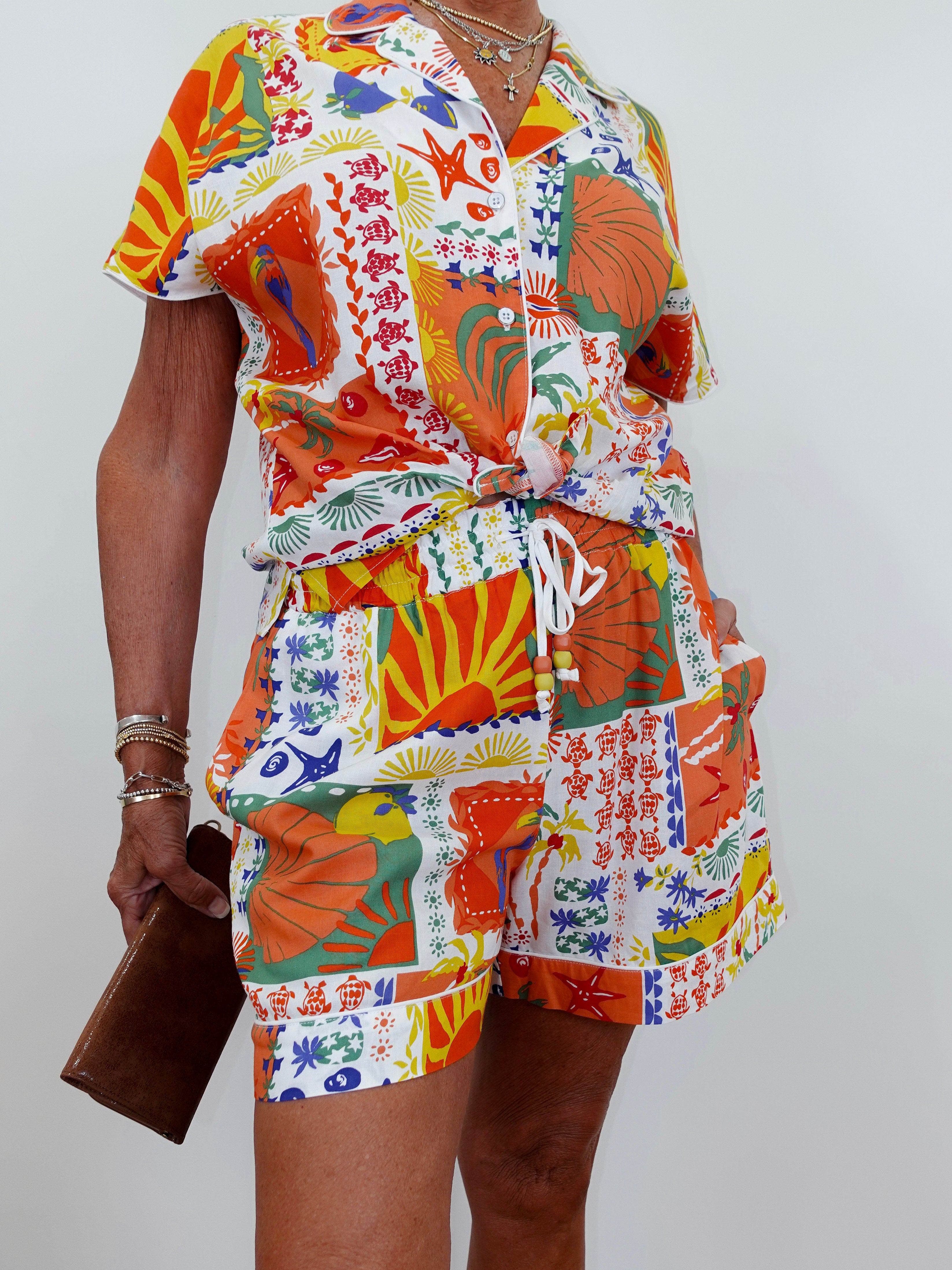 Person wearing a colorful patterned outfit with a belt against a white background