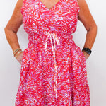 Person wearing a red and white patterned dress on a plain background