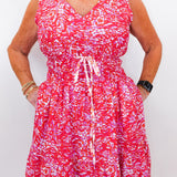 Person wearing a red and white patterned dress on a plain background