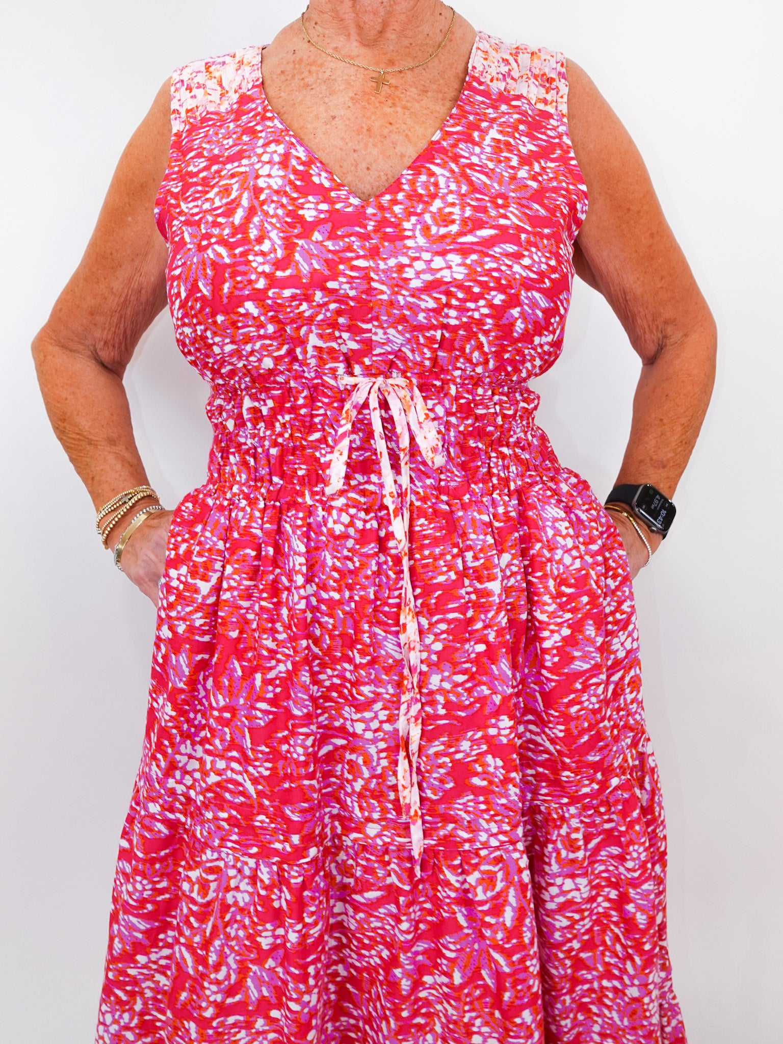 Person wearing a red and white patterned dress on a plain background