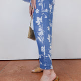 Person wearing blue floral pants with a plain background