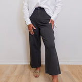 woman wearing a high rise fly front capri with front pockets in front of a white background. 