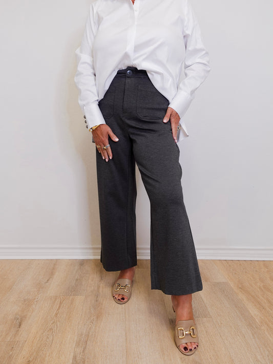 woman wearing a high rise fly front capri with front pockets in front of a white background. 
