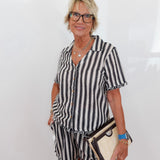 Woman wearing a black and white striped dress with a plain background