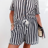Black and white striped romper worn by a person on a white background