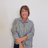 Woman wearing a striped shirt against a plain background