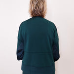 Person wearing a green tracksuit against a white background