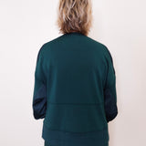 Person wearing a green tracksuit against a white background