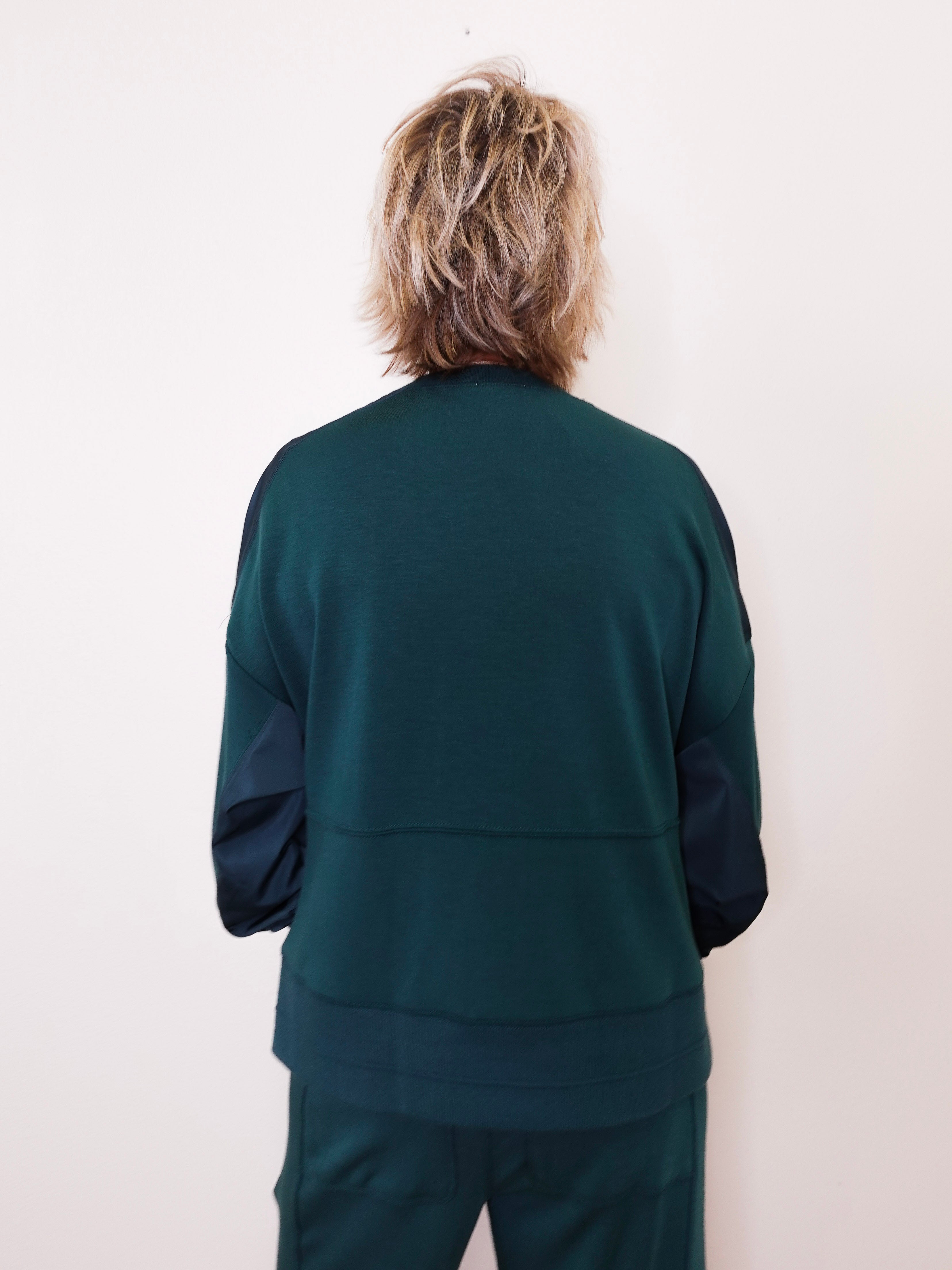 Person wearing a green tracksuit against a white background