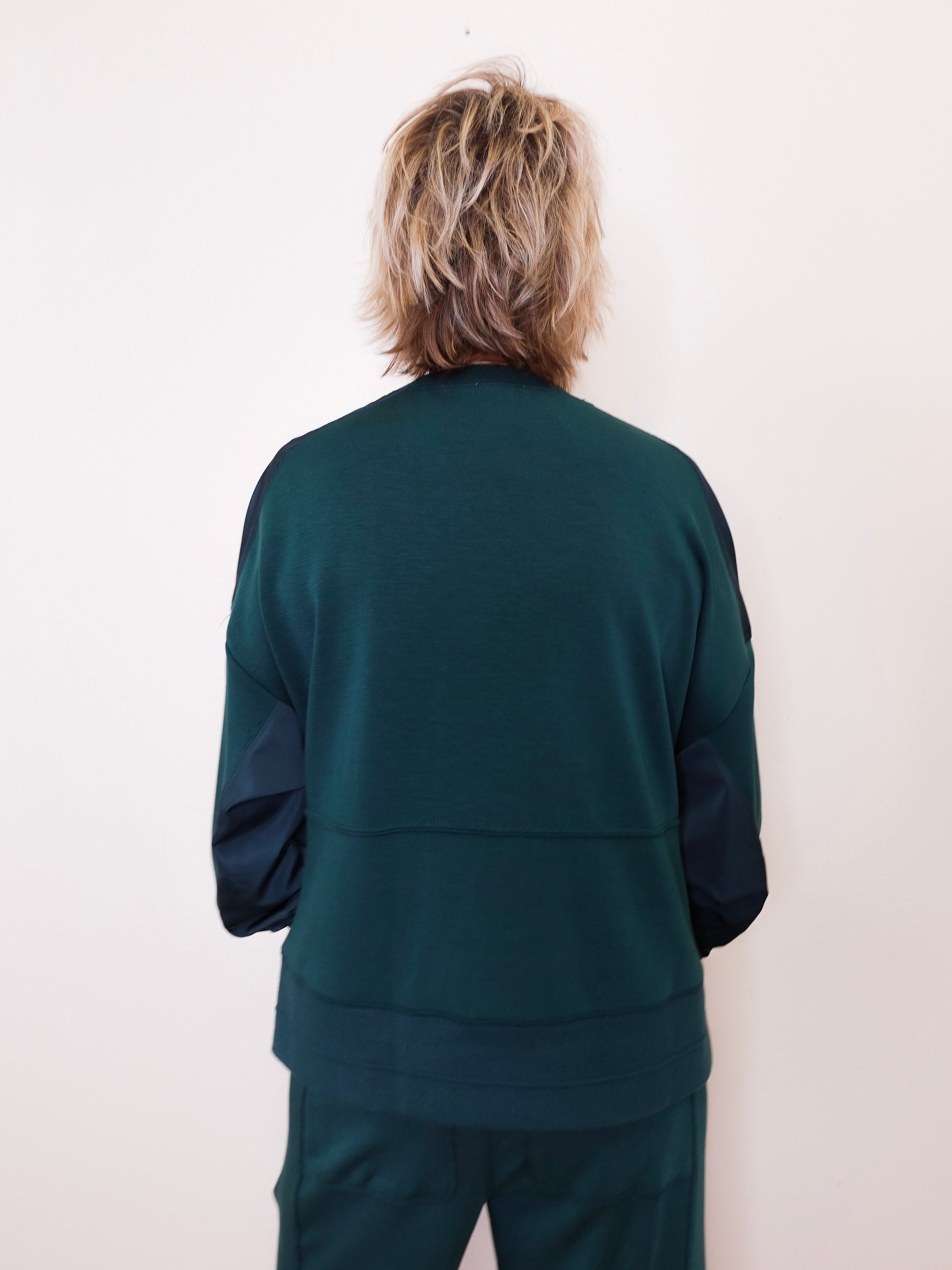 Person wearing a green tracksuit against a white background