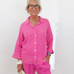 Woman wearing a pink outfit against a white background