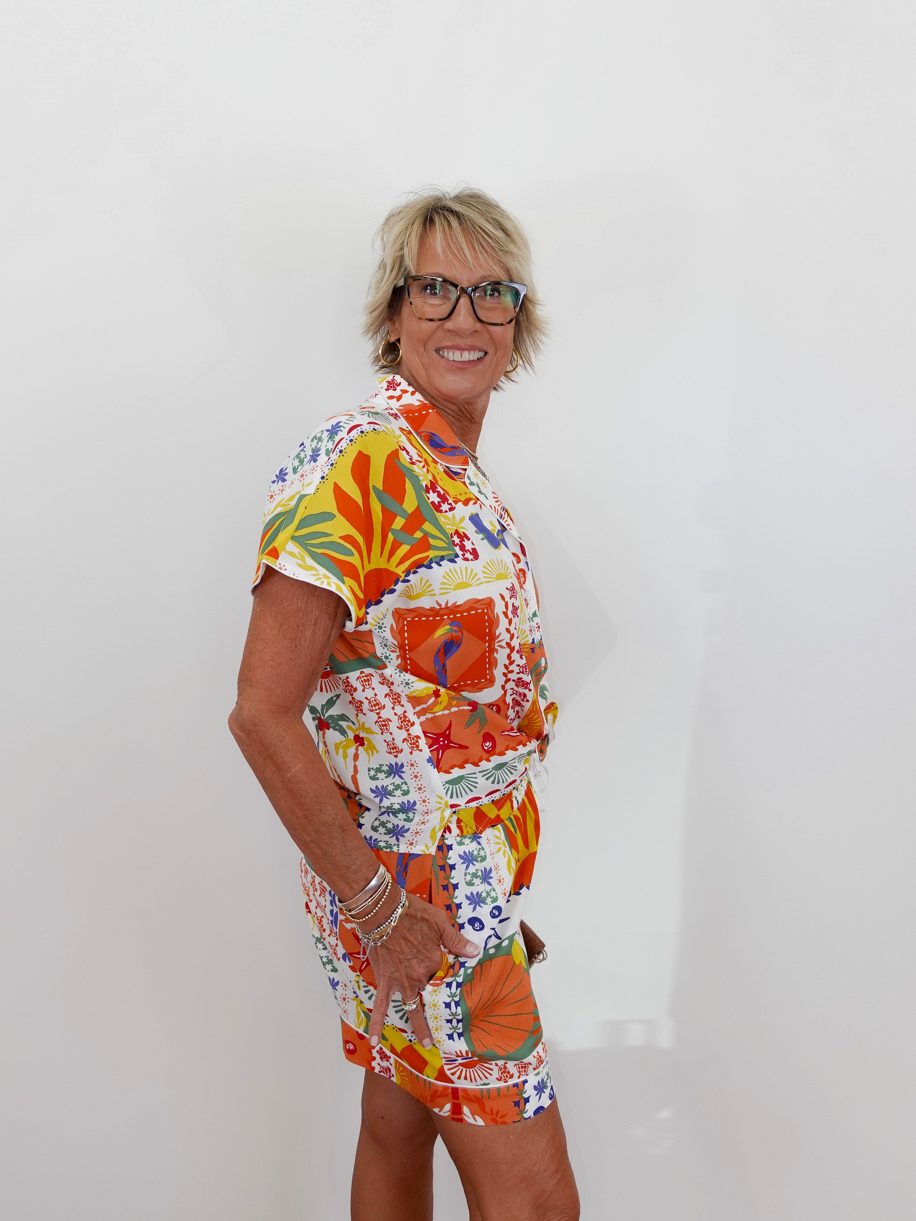 Woman wearing a colorful patterned outfit against a white background
