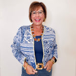 Woman wearing a blue and white patterned jacket with a plain background