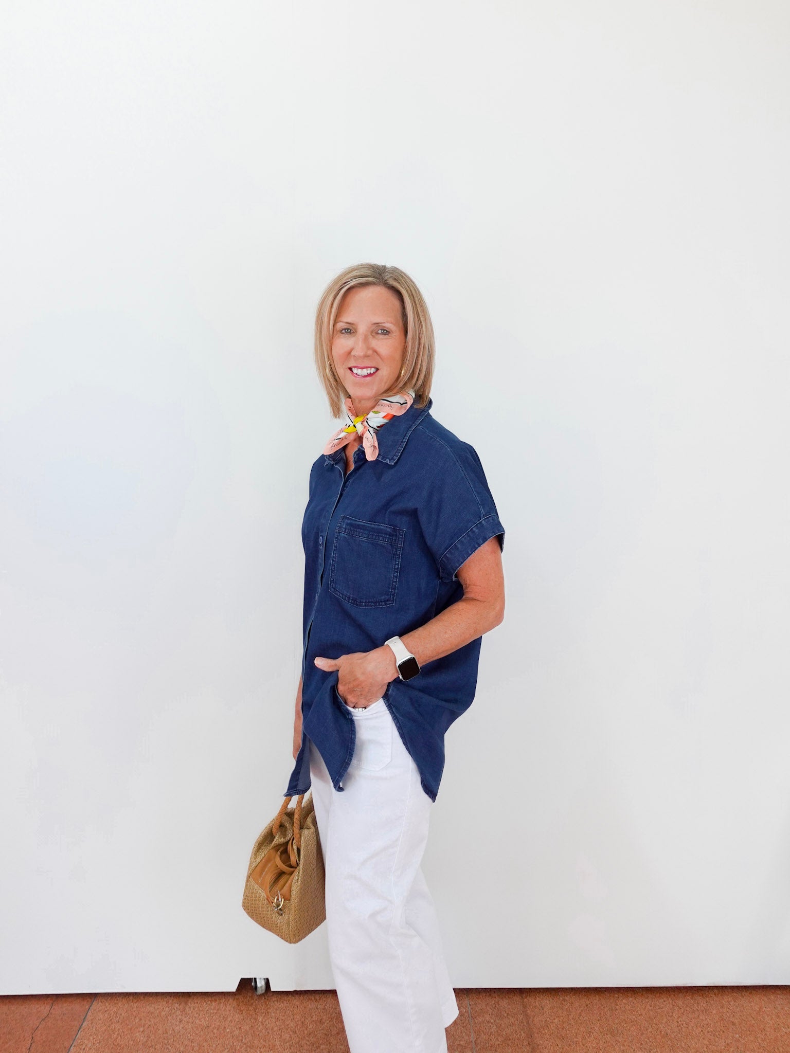 Woman wearing a blue shirt and white pants against a white background