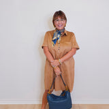woman wearing a tribal short sleeve dress that's a tan suede. 