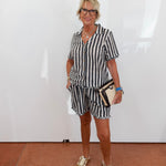 Woman wearing a black and white striped dress with a white background
