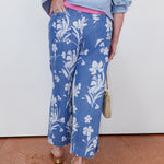 Person wearing blue floral pants with a white background