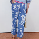 Person wearing blue floral pants with a white background