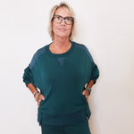 Woman wearing a green outfit against a white background