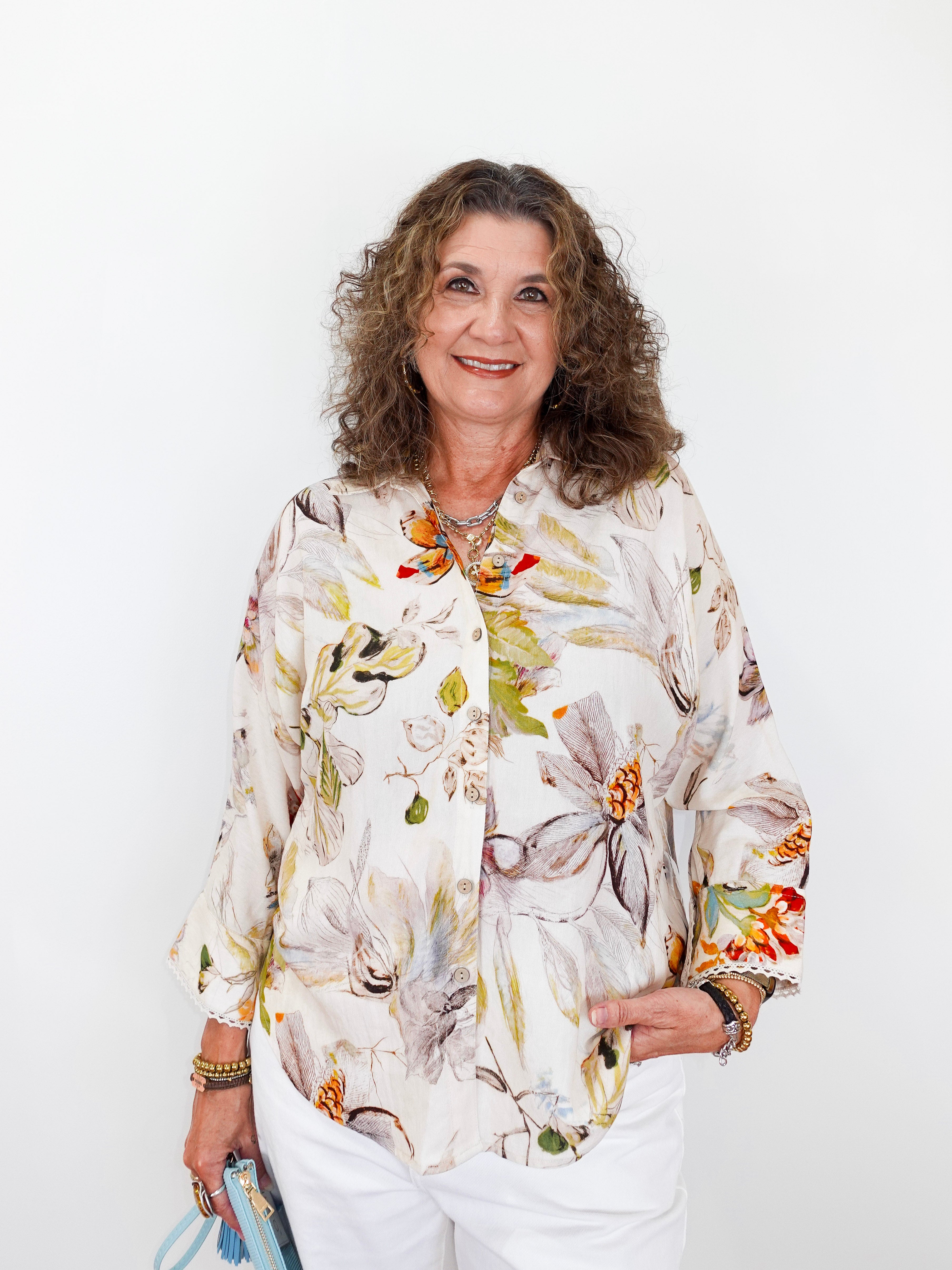 Woman wearing a floral blouse against a white background