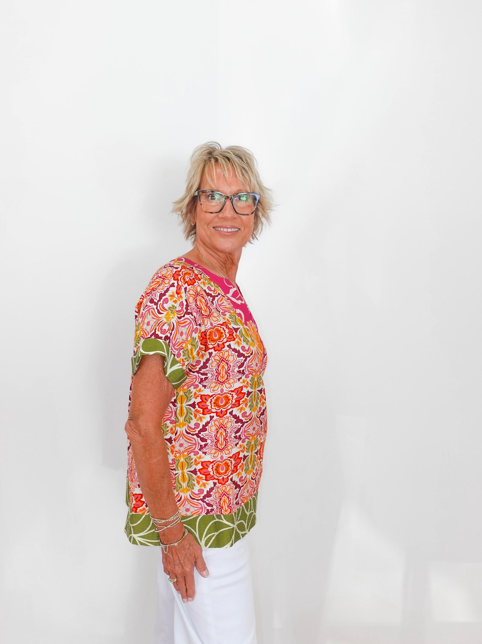 Woman wearing a colorful patterned shirt against a white background