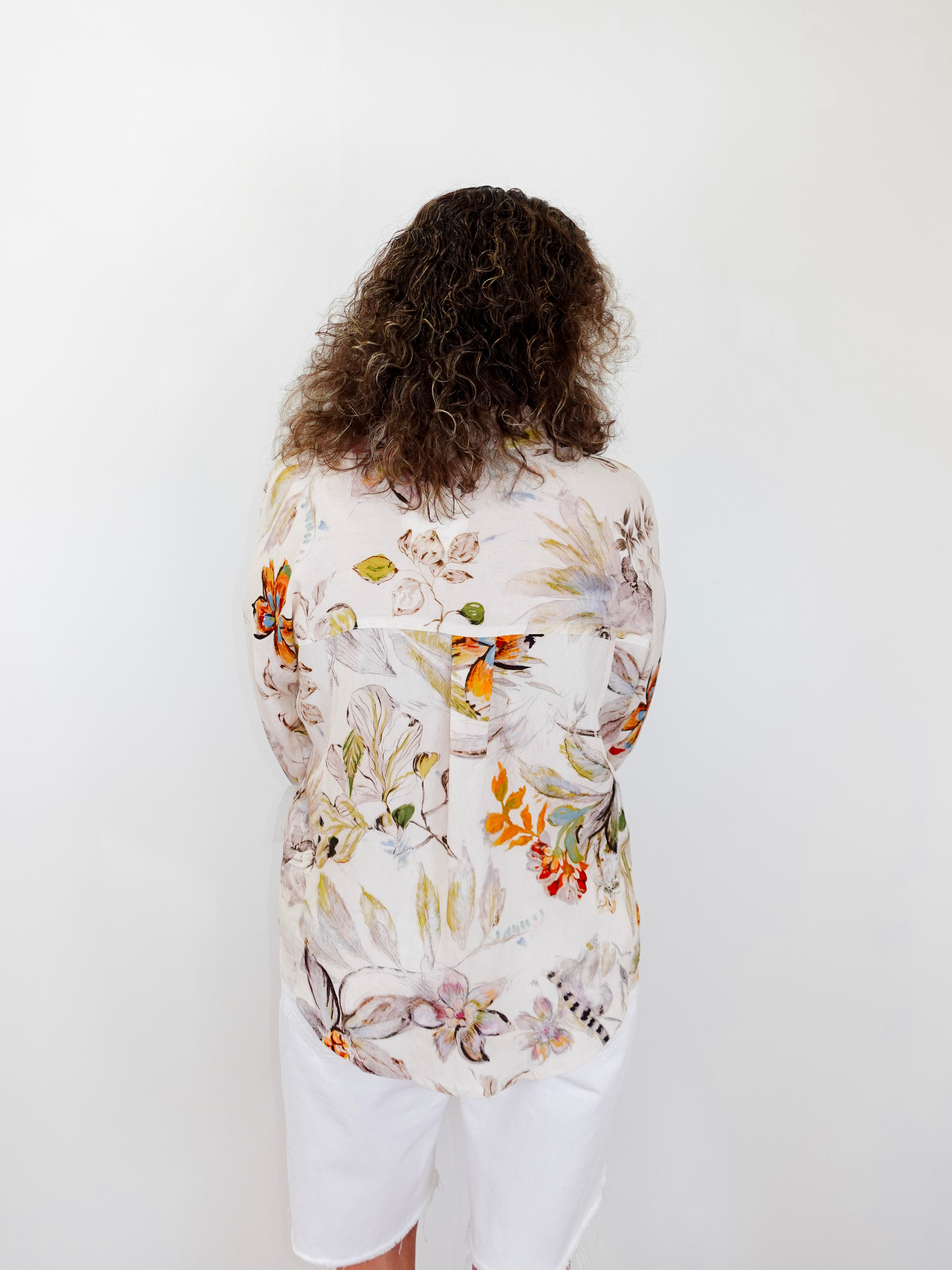 Person wearing a floral shirt with a white background