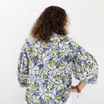 Person wearing a floral patterned shirt on a white background