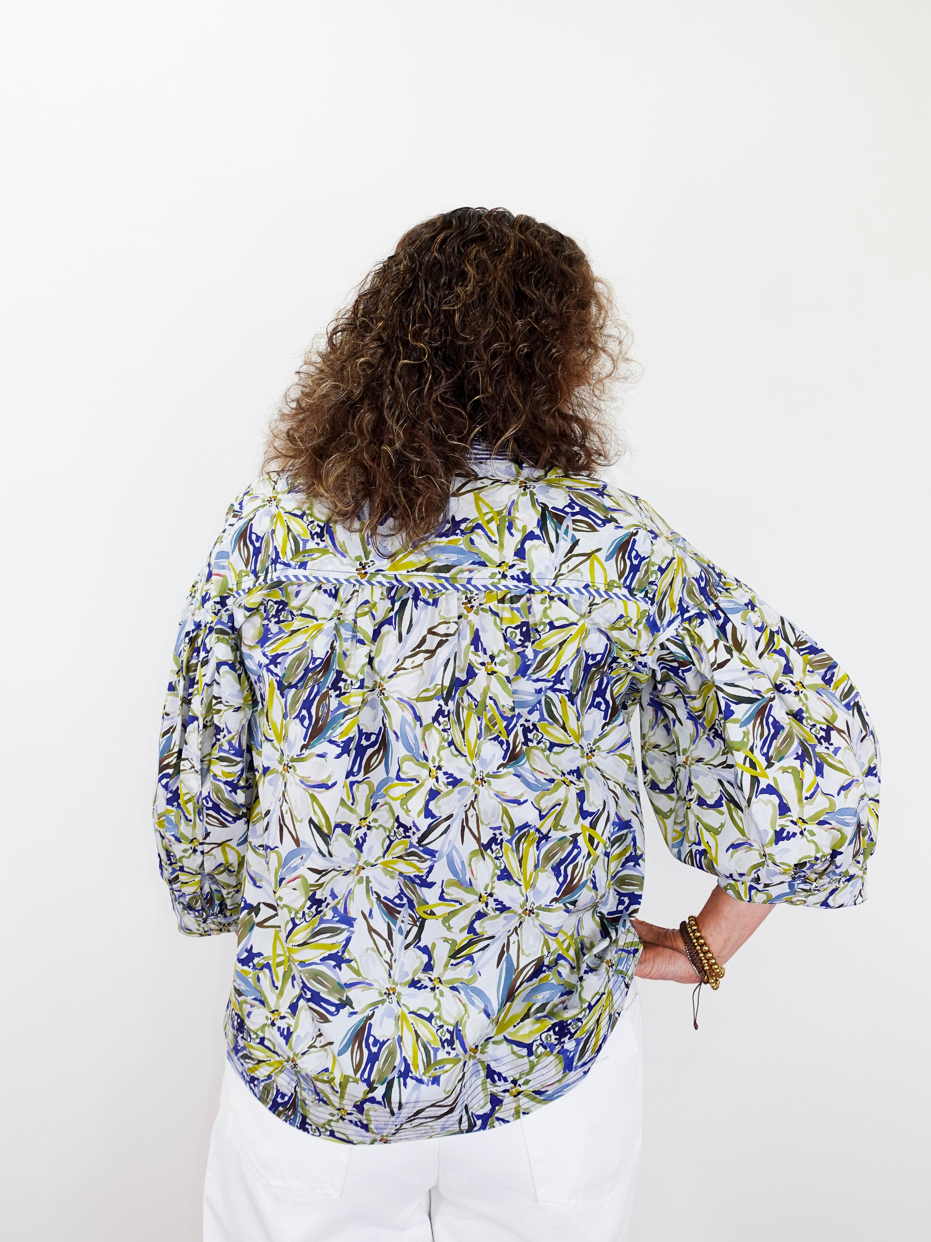Person wearing a floral patterned shirt on a white background