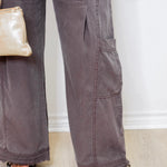 Person wearing gray pants with a white wall background