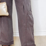 Person wearing gray pants with a white wall background