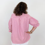 Person wearing a red and white striped shirt against a plain background