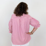Person wearing a red and white striped shirt against a plain background
