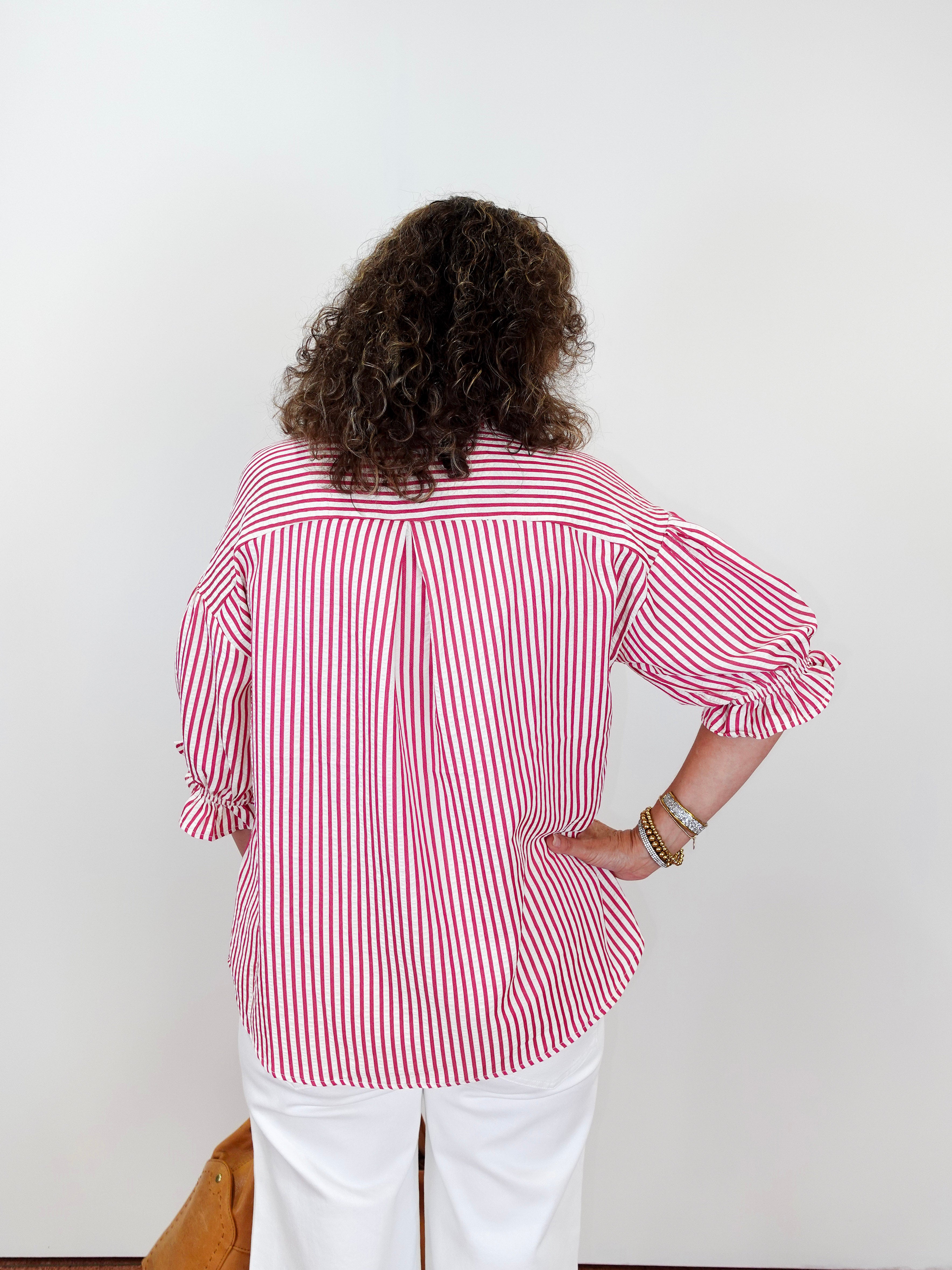 Person wearing a red and white striped shirt against a plain background