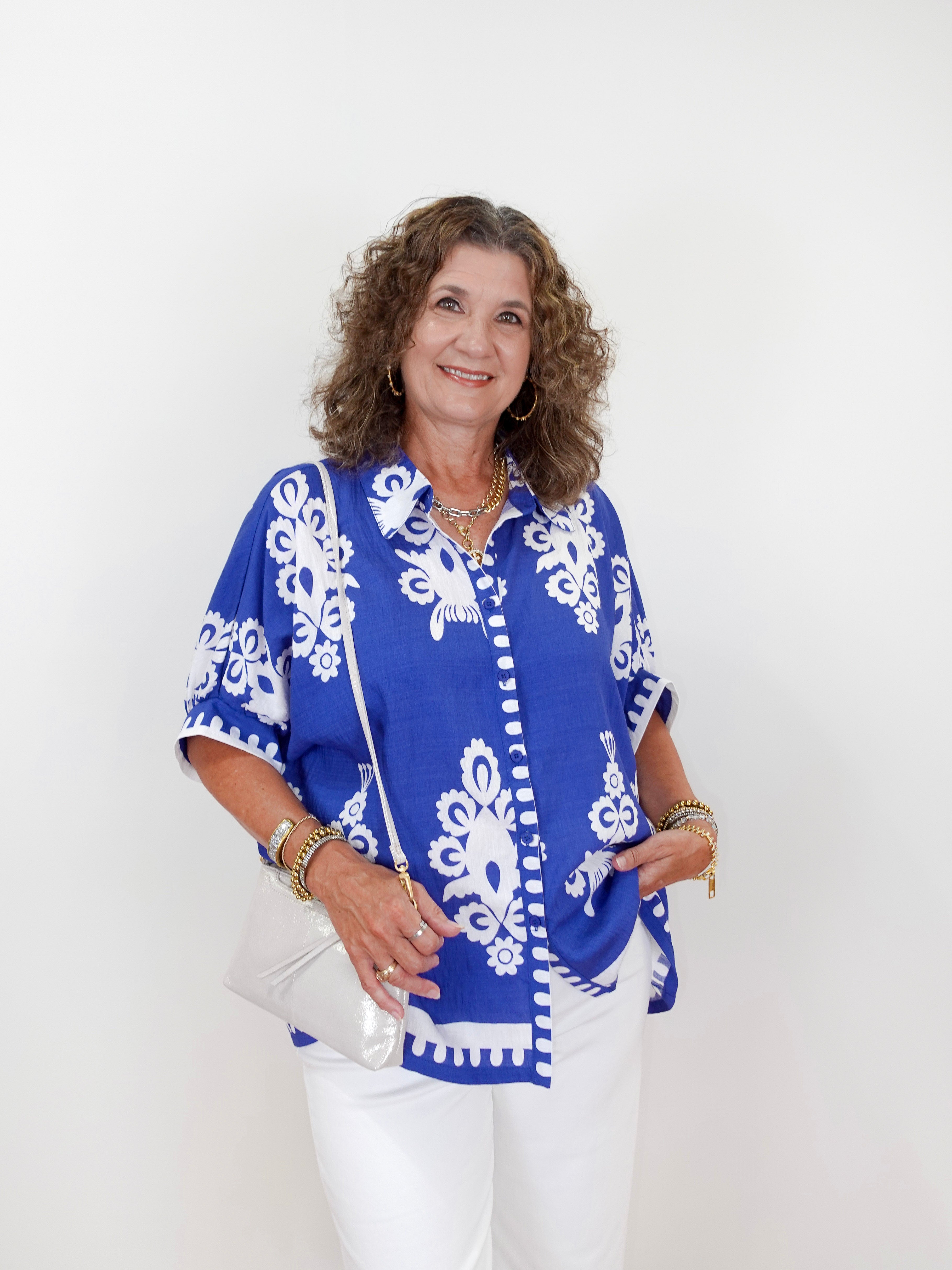 Woman wearing a blue and white patterned blouse against a white background