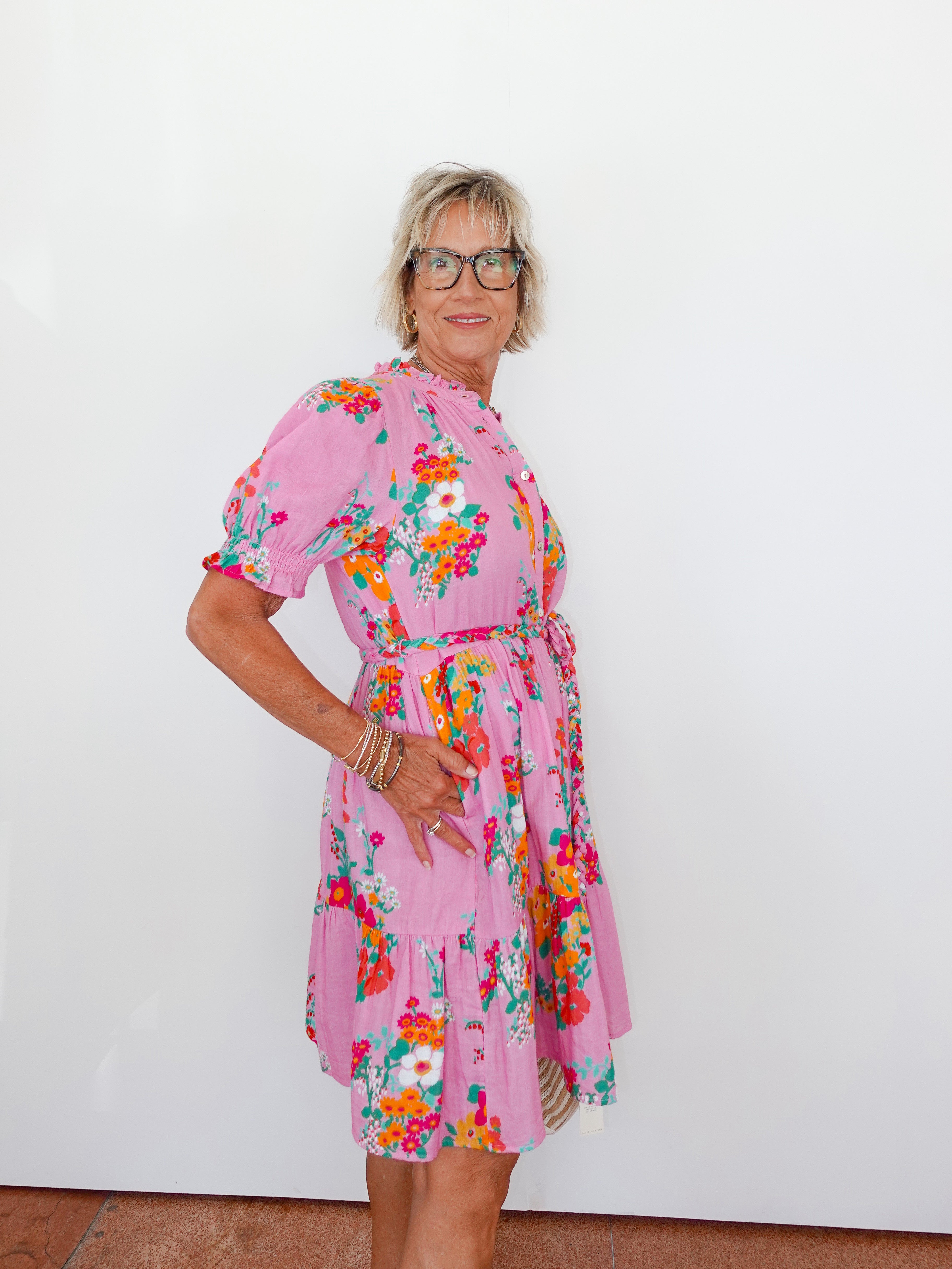 Woman wearing a pink floral dress against a white background