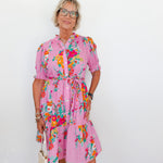Woman wearing a pink floral dress against a white background