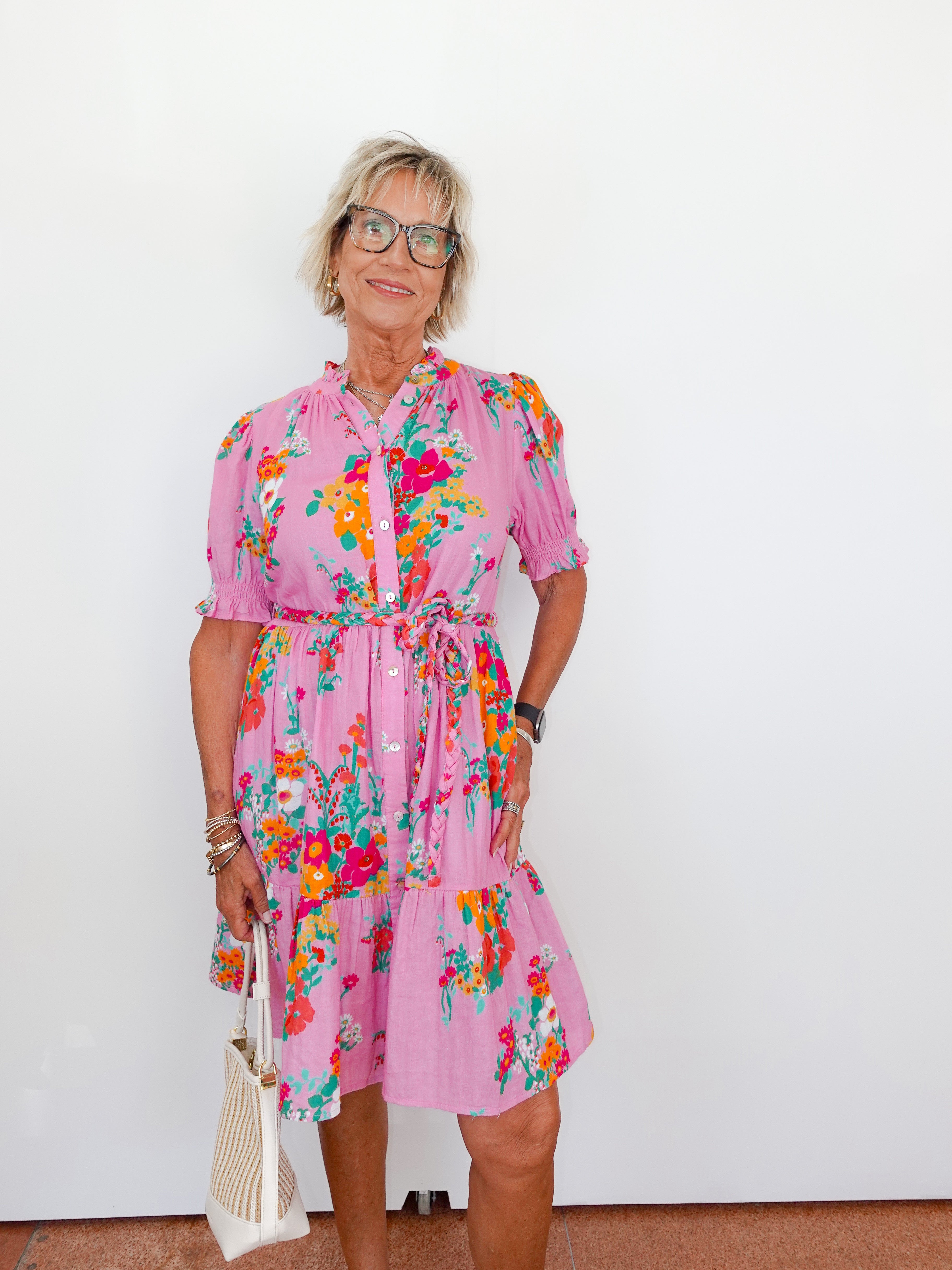 Woman wearing a pink floral dress against a white background