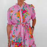 Woman wearing a pink floral dress against a white background