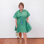 Woman wearing a green dress with a white background