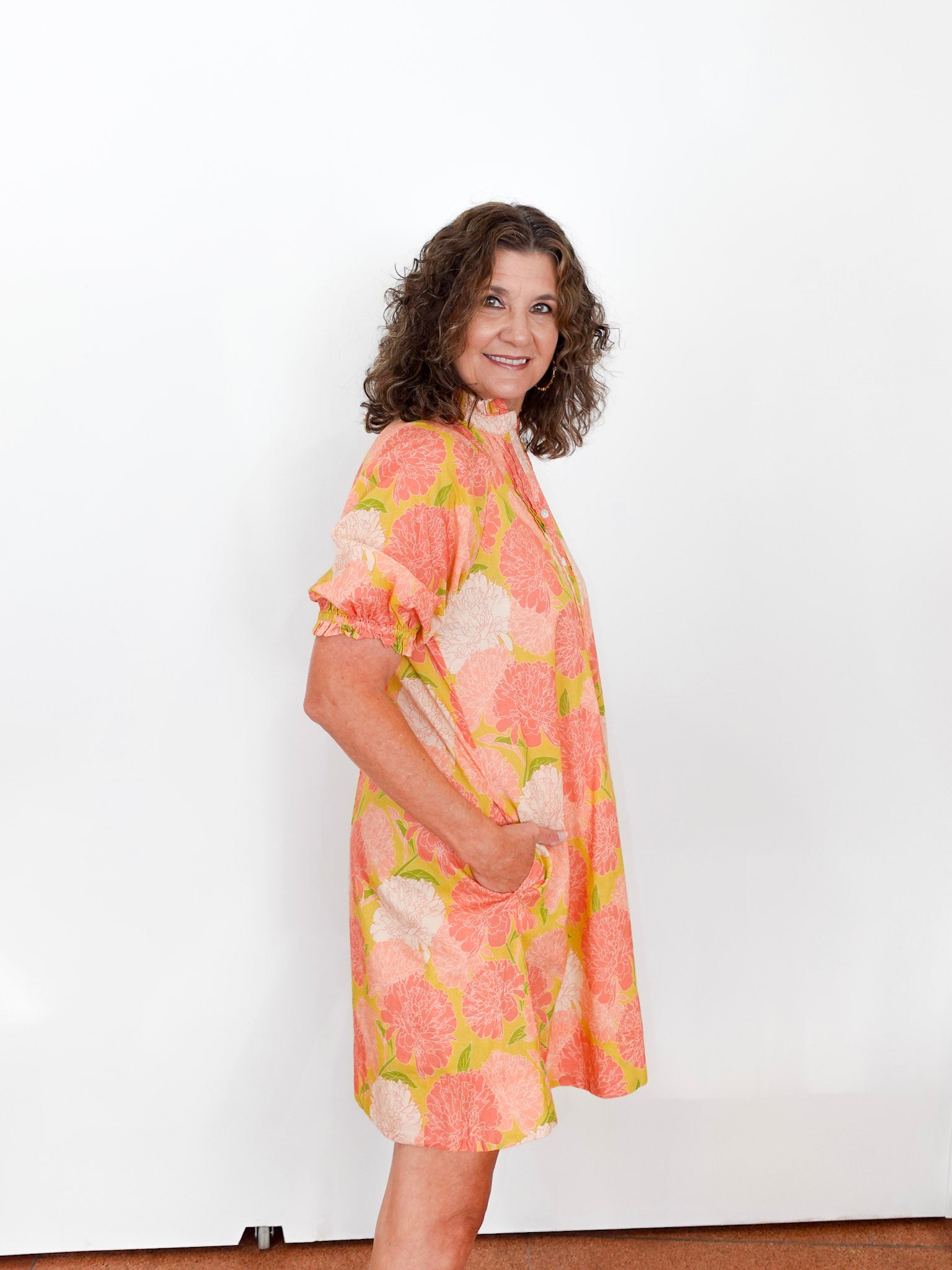 Woman wearing a floral dress against a white background