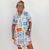 Woman wearing a colorful patterned dress against a white background