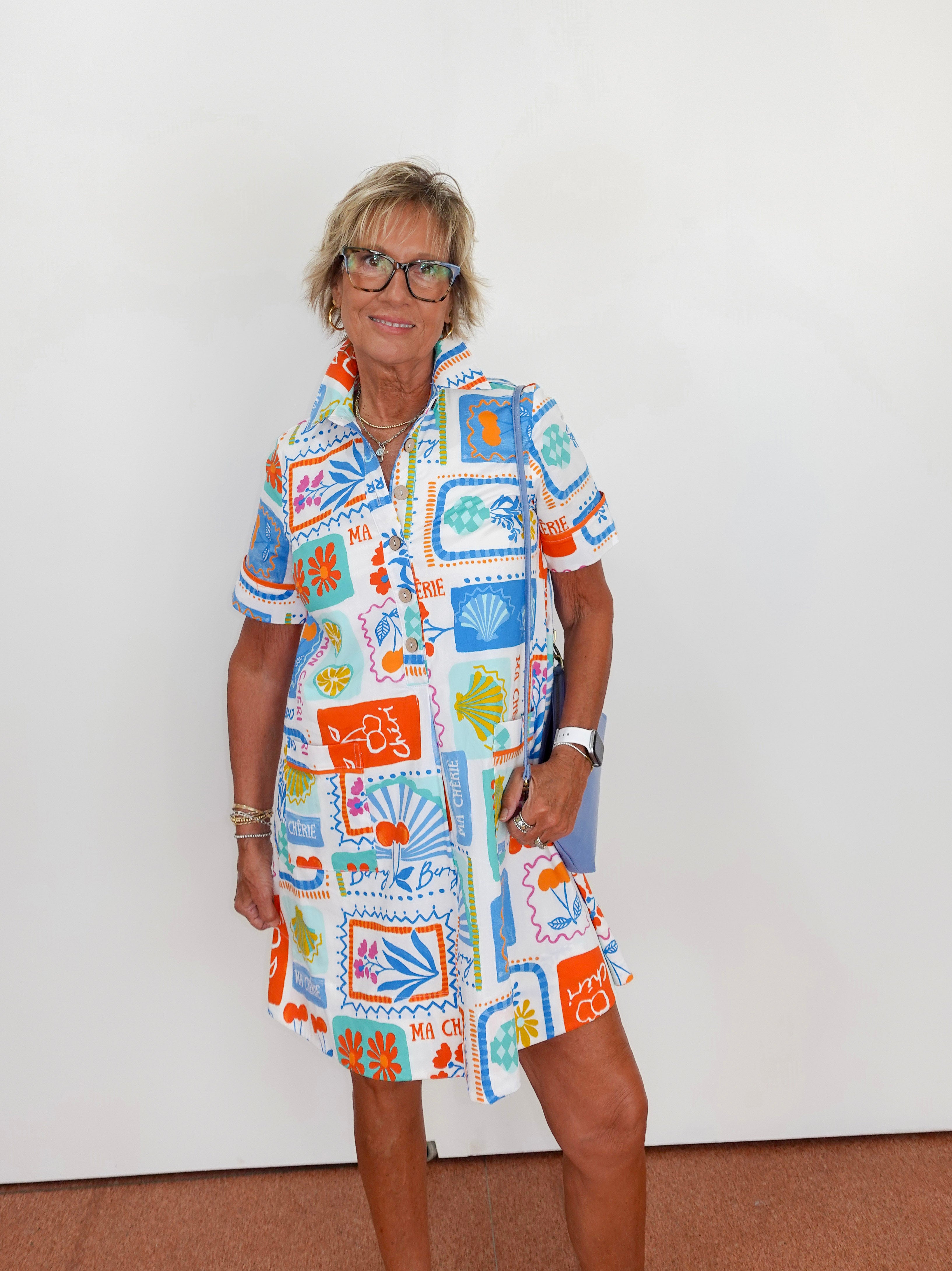 Woman wearing a colorful patterned dress against a white background
