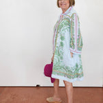 Woman wearing a patterned dress with a white background