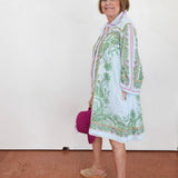 Woman wearing a patterned dress with a white background
