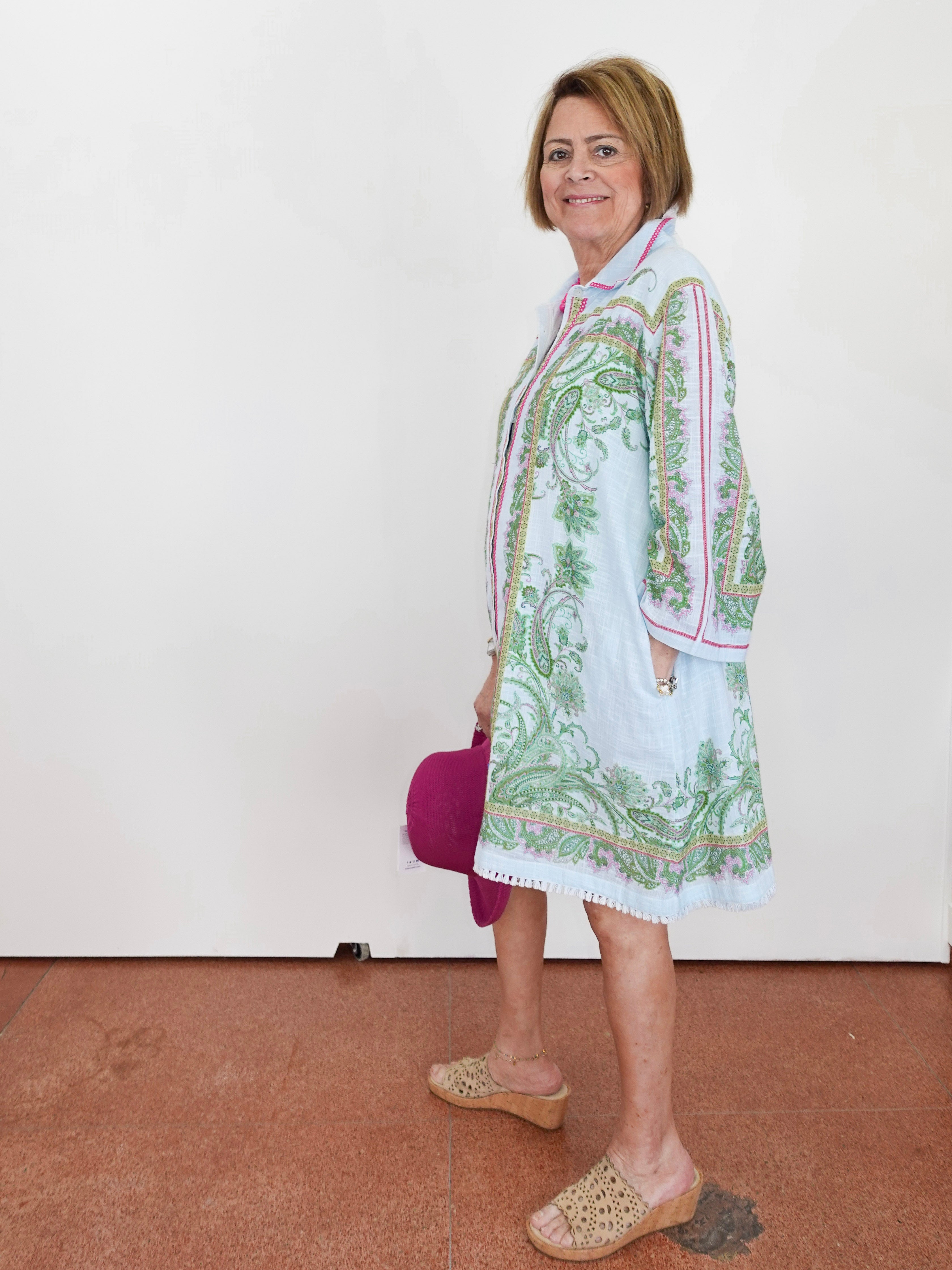Woman wearing a patterned dress with a white background