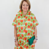 Woman wearing a colorful patterned dress against a white background